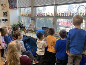 5 and 6 year olds observing feeders out a classroom window.